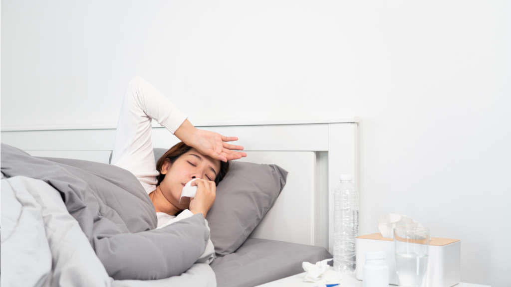 alergija pelėsiui - moteris guli lovoje ir čiaudi