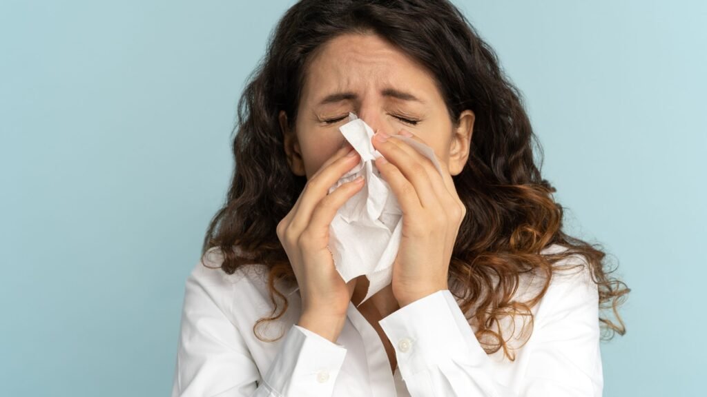a girl sneezes - one of the main symptoms of mould allergy